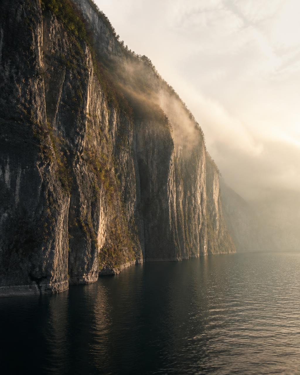 Les falaises calcaires de la Dent du Chat tombant à pic dans l'eau sombre